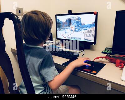 Little boy playing Minecraft on a PC Stock Photo