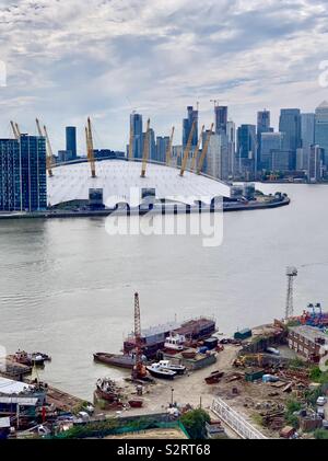 Greenwich, UK - 5 July 2019: The 02 Arena seen across the River Thames from the Emirates Air Line cable car. Canary Wharf in the distance. Stock Photo