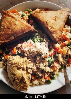 Samosas, vegetable couscous and humous Stock Photo