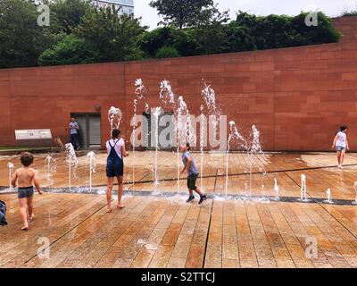Summer fun with water fountains. Kids cooling off. Stock Photo