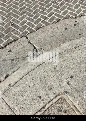 Patterns on street corner, with curved concrete curb and inlaid bricks Stock Photo