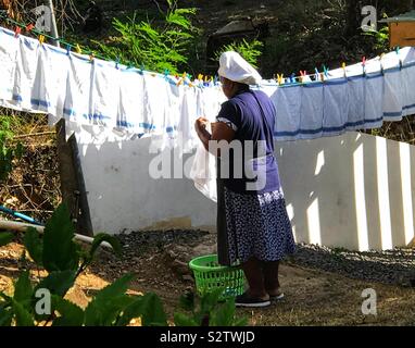 Lady Hanging Out a Washing Line Full Of Tea Towels On the Island Of Bequia- St.Vincent and the Grenadines Stock Photo