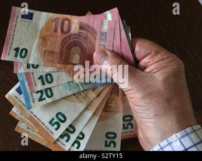 A handful of euro notes in the UK on the day the exchange rate for sterling fell even further because of Brexit statements by the government (6th August, 2019). Stock Photo