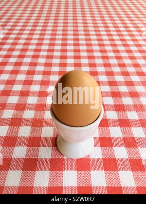 Egg in an egg cup on red and white background Stock Photo