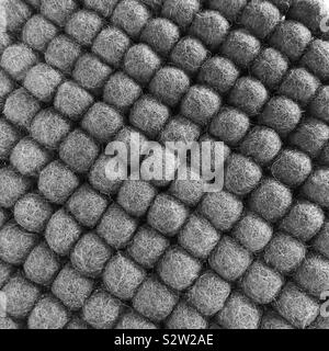 A closeup of grey wool balls lined up in diagonal rows Stock Photo