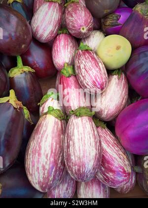 Display of tear drop and graffiti types of eggplant in the produce aisle of a grocery store Stock Photo