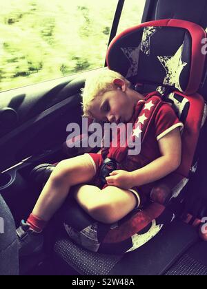 Two year old boy sleeping in the car Stock Photo