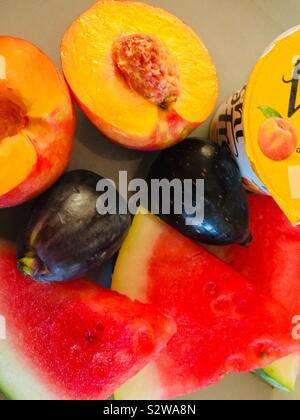 Healthy breakfast! - Watermelon slices, fresh figs, nectarine and yogurt on a duck egg coloured plate Stock Photo