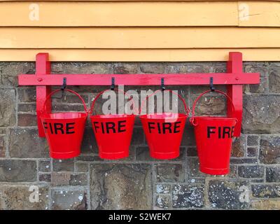 Red fire buckets at Instow old railway station on the Tarka Trail, North Devon. Stock Photo