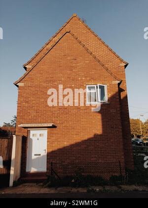 Bright evening light causing light on the side of a house Stock Photo