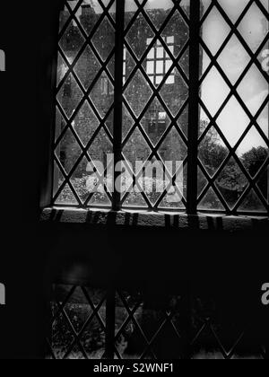 Black and white image ruins of Hardwick Old Hall seen through leaded windows. Tudor period house built between 1587-96 for Bess of Hardwick, Elizabeth Shrewsbury Stock Photo