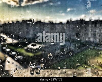Raindrops on window with evening sun Stock Photo