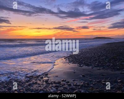 Sunset afterglow at Llangennith beach, with Burry Holms in the distance, Gower, Swansea, South West Wales, August. Stock Photo