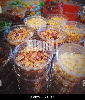 Neatly stacked nuts and candies in plastic containers for sale in the produce aisle of the grocery store, United States Stock Photo