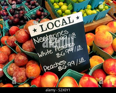 Local farm to table nectarines and peaches for sale in a farmers market, USA Stock Photo