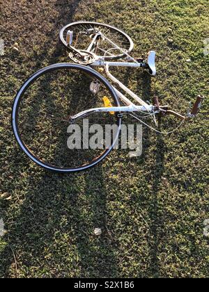 Old white bicycle abandoned on the grass. Stock Photo