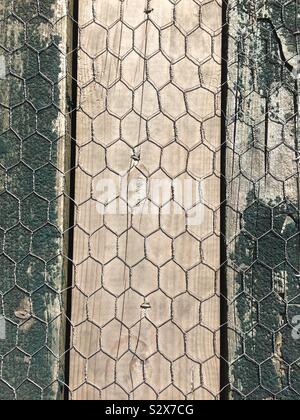Chicken wire on wooden planking - textures Stock Photo