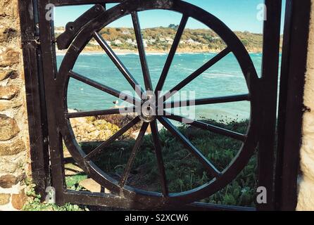 View of Coverack Beach Through a Cartwheel Gate - Cornwall UK Stock Photo