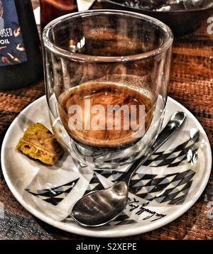 Double Espresso in Double Walled Glass On A Patterned Saucer with A Honeycomb Biscuit and Spoon Stock Photo