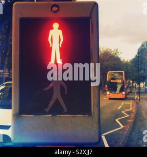 A pelican crossing with the ‘red man’ lit up and white zigzags on the road Stock Photo