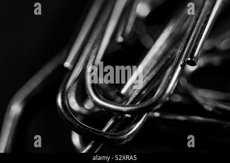 a bunch of paperclips are lying on a black table and shining Stock Photo
