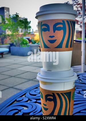 Starbucks to go coffee cups stacked on a table on a apartment building sundeck in midtown Manhattan, NYC, USA Stock Photo