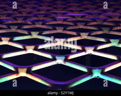 Background abstract: metal grill lit my purple lights in night club Stock Photo