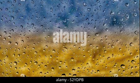 water droplets on glass with a colourful background Stock Photo