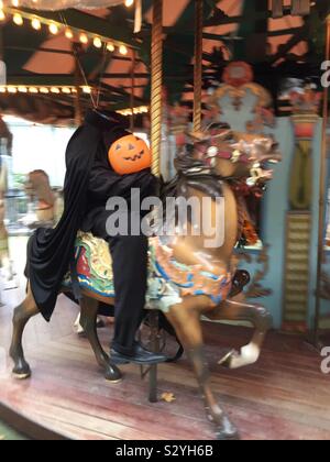 Headless horseman statue on a carousel horse during the Halloween season on a merry-go-round in Bryant Park, NYC, USA Stock Photo