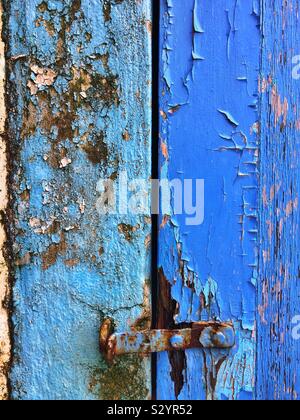 Latch on an old blue painted wooden door. Stock Photo