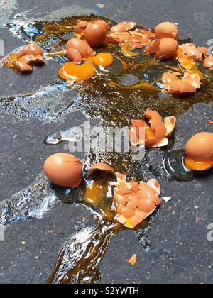 Close up of a dozen brown eggs broken on a sidewalk in New York City, USA Stock Photo