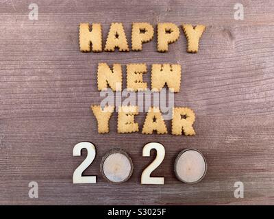 Happy New Year 2020 text composed with biscuit letters and wooden numbers Stock Photo