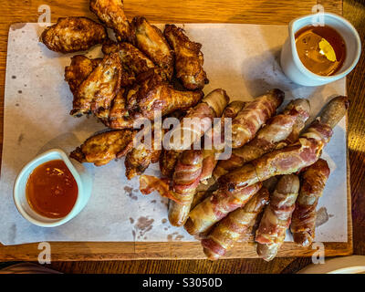 Pigs in blankets and chicken wings Stock Photo