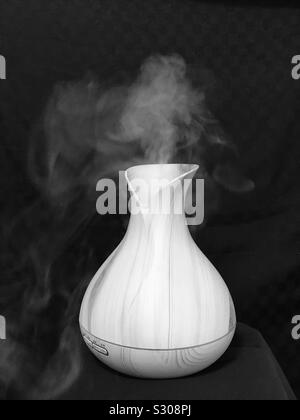 Wooden bamboo essential oil air diffuser, close up pic of air Humidifier with steam -Vaporizing Stock Photo