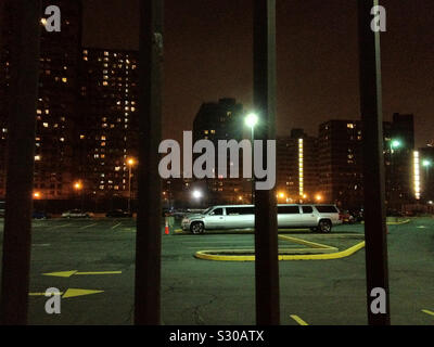 Silver stretch limo parked in lonely parking lot at night, Brooklyn, New York, USA. 2013. Stock Photo