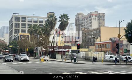 LOS ANGELES, CA, NOV 2019: view at intersection of Hill and 4th Streets in Downtown, with palm trees, buildings and City Hall in the distanc Stock Photo