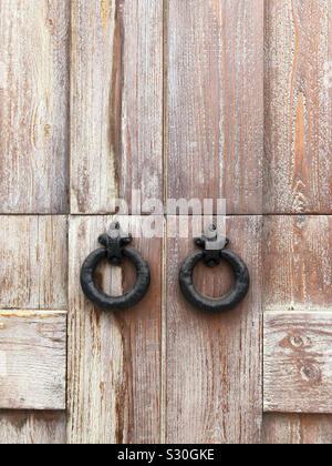 Up close of iron door handles on wooden door. Stock Photo