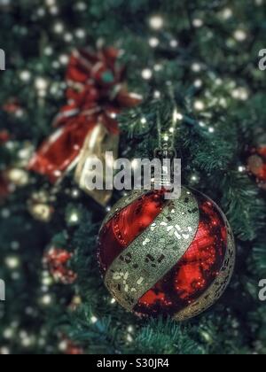 Closeup of a red and gold Christmas ornament hanging on a tree Stock Photo