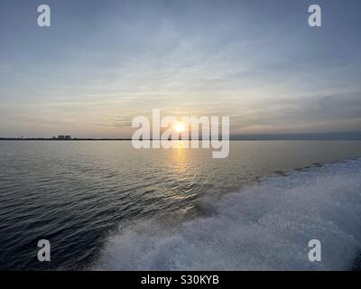 Sunset on Gulf of Mexico water from a boat with water spray from the boat Stock Photo