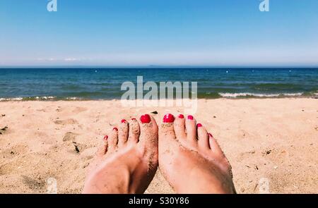 Sunbathing toes at the beach in summer Stock Photo