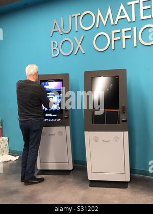 Senior man at an  automated box office purchasing a movie ticket. Stock Photo