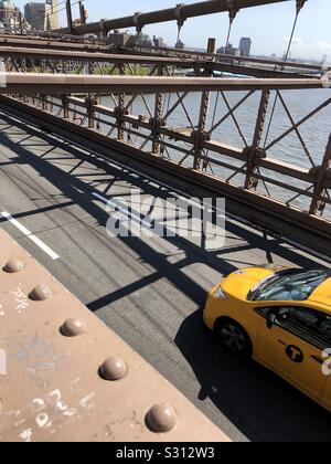 Yellow taxi on Brooklyn Bridge, New York Stock Photo