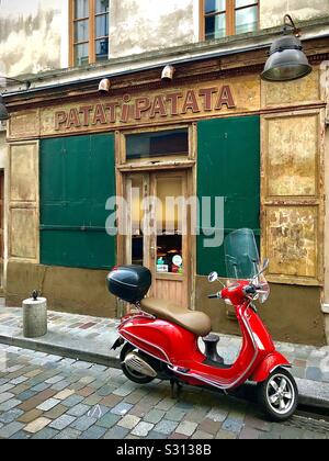 Red scooter outside « Patati-Patata » restaurant in the Bastille quarter of Paris, France. Stock Photo