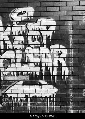 “KEEP CLEAR” written graffiti in brick wall in black and white. Stock Photo