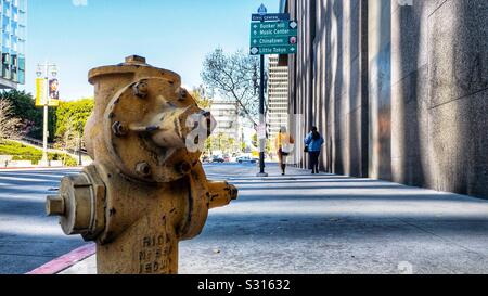 LOS ANGELES, CA, DEC 2019: looking past soft-focus fire hydrant in foreground to pedestrians walking on sidewalk at Bunker Hill in Downtown Stock Photo