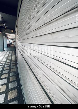 Steel roll down shop front and walkway Stock Photo