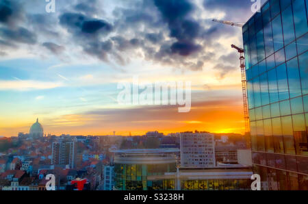 Colorful sunrise and dark dramatic clouds over the business district of the city and reflected in the windows of the office buildings Stock Photo