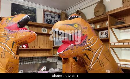 Dinosaurs fighting in a bakery Stock Photo