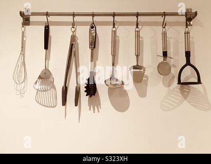 Kitchen utensils hanging on hooks Stock Photo