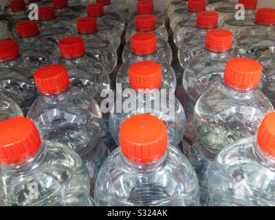 Rows of plastic water bottles on a supermarket shelf. Stock Photo